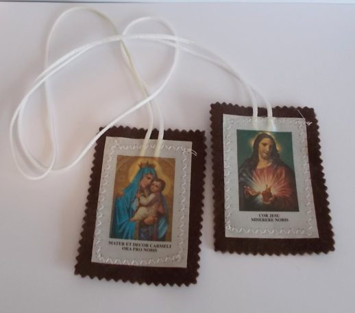 Zwei religiöse Medaillen mit Abbildungen von Maria und Jesus Christus, an einem Faden befestigt.