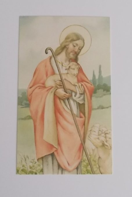 Eine biblische Figur trägt ein Kind und hält einen Stock in ländlicher Umgebung.