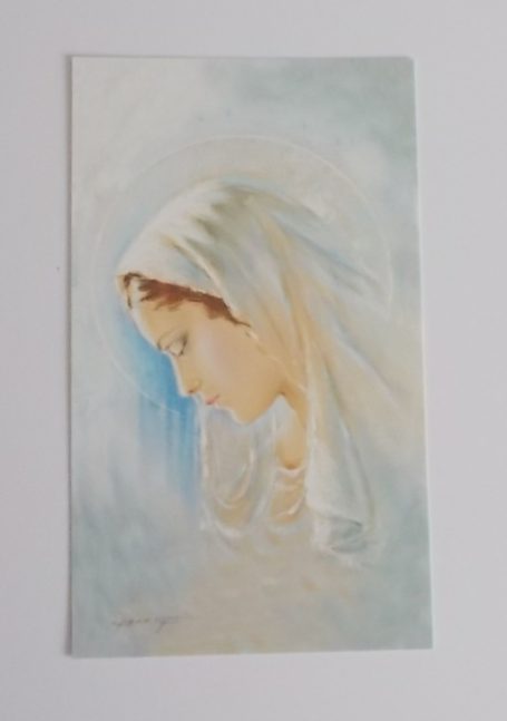 Eine nachdenkliche Frau mit weißen Kopftuch, sanften Farben und einem ruhigen Ausdruck.